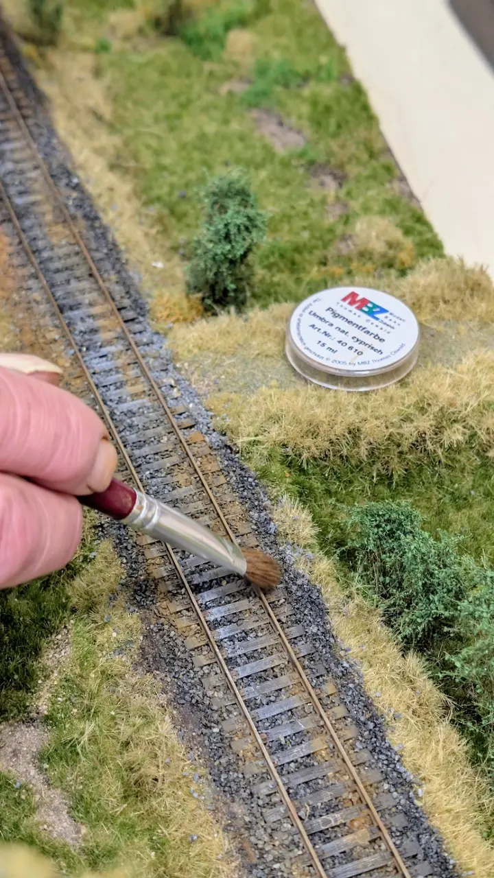 Ferdi arbeitet Pigmente mit einem Pinsel am Gleis ein