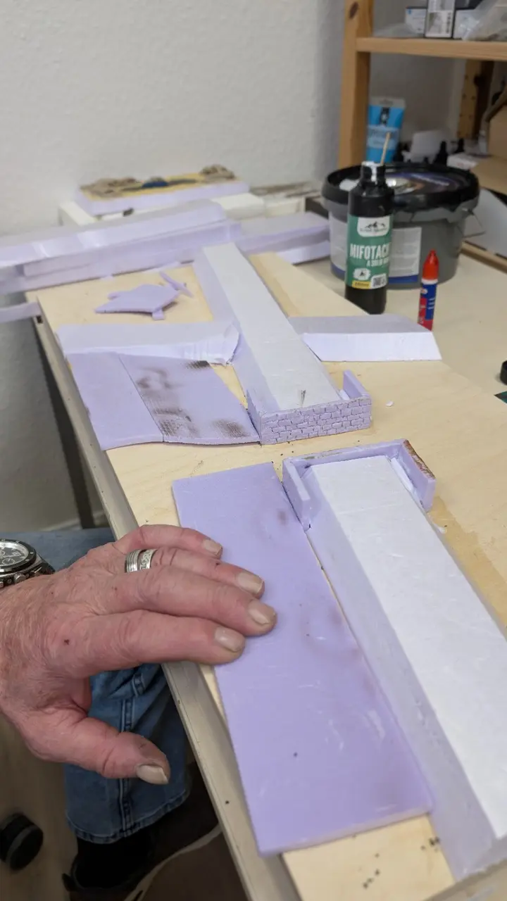 Ferdi baut die Grundform eines Modellbahndioramas aus Hartschaum auf