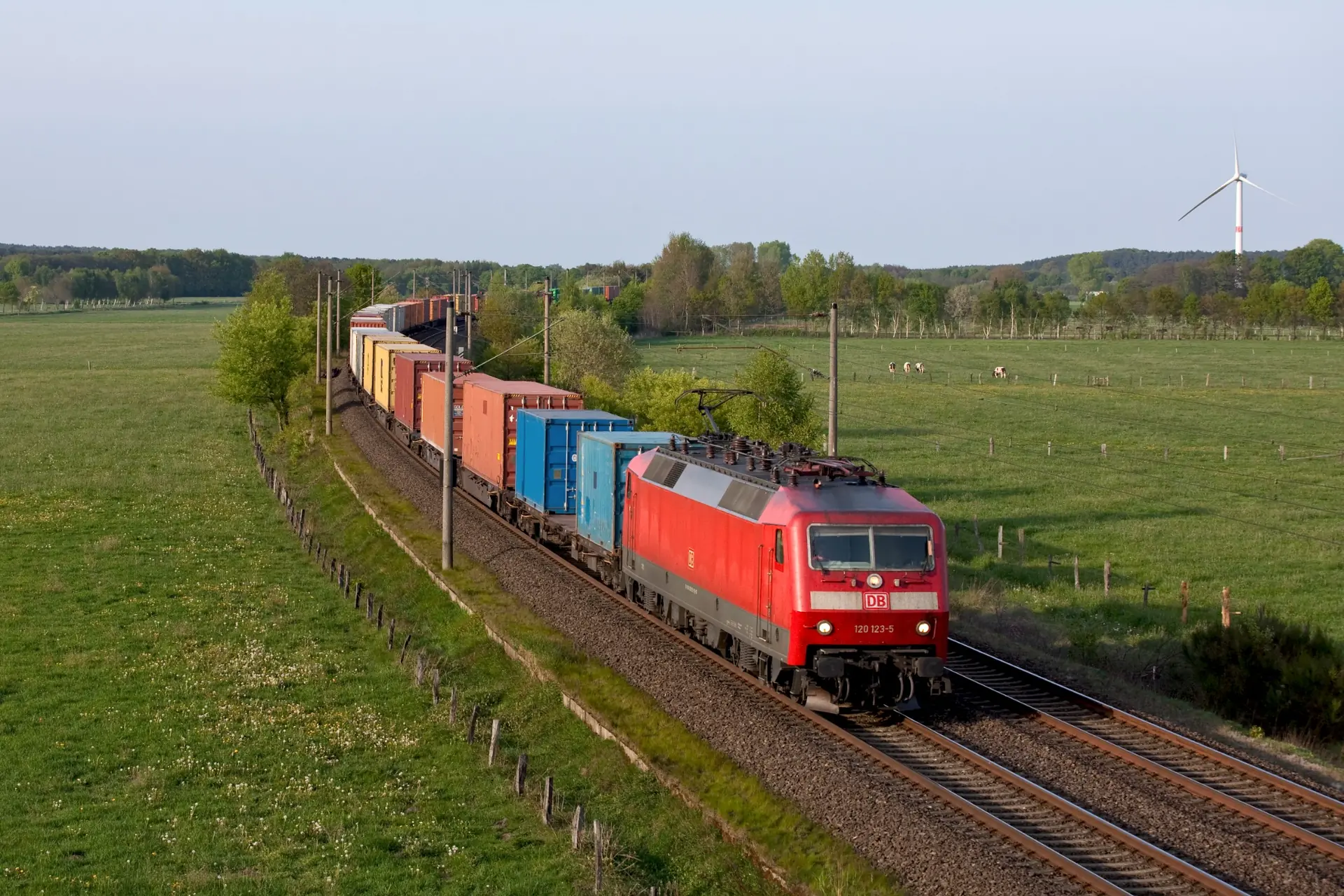 Vorbildaufnahme eines G&uuml;terzuges auf einer Strecke durch offene Wiesen und Feldflur