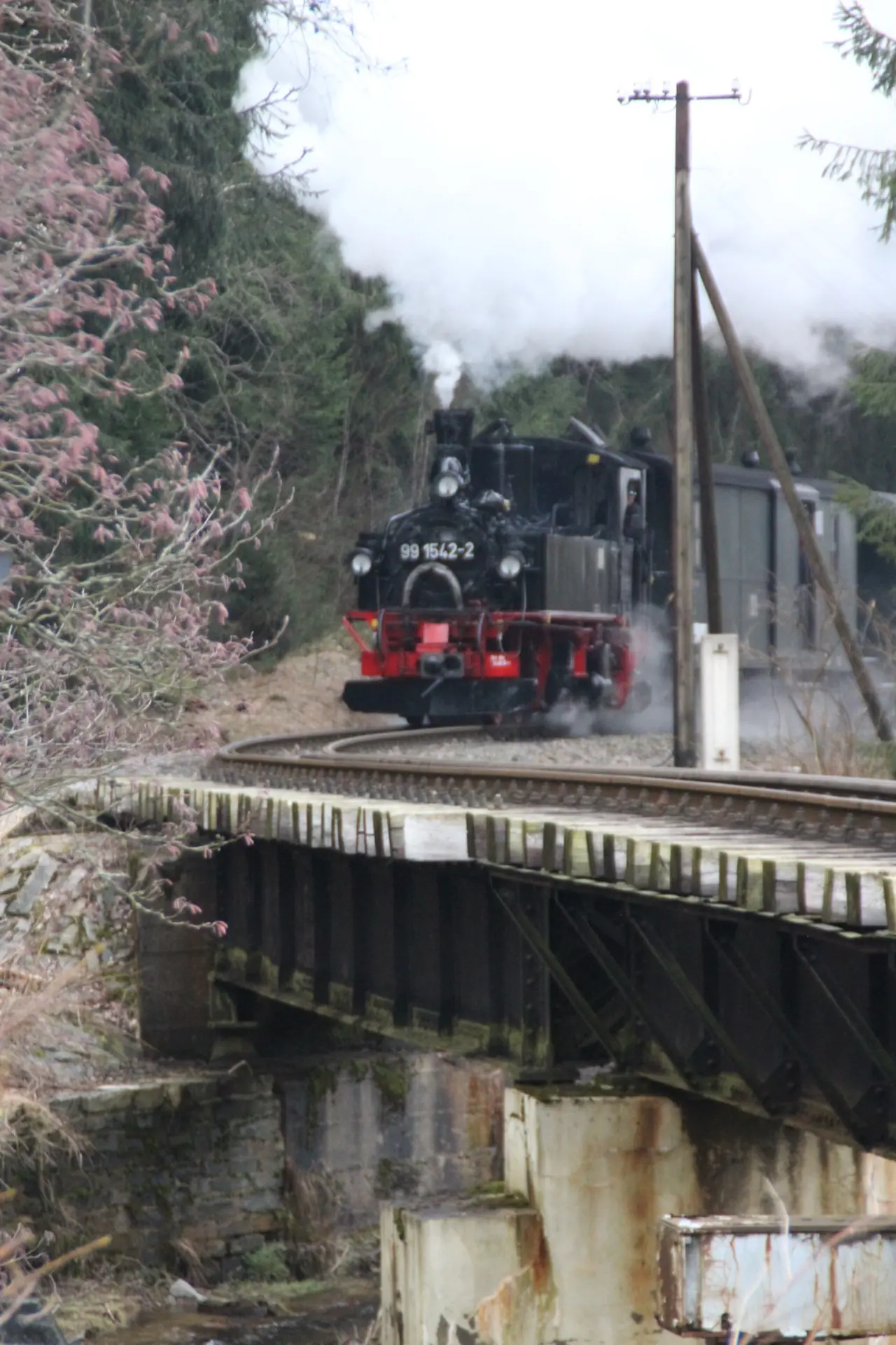 Vorbildaufnahme einer kleinen Dampflokomotive auf einer Br&uuml;cke einer Nebenbahn