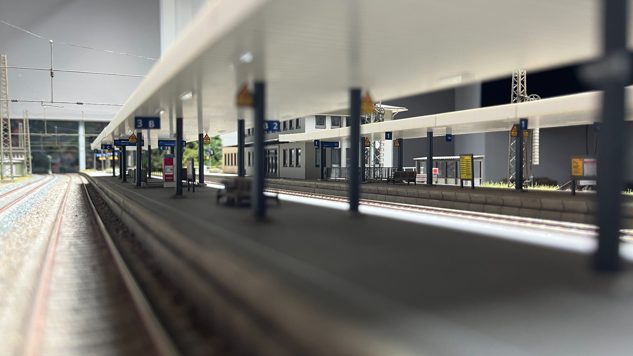 Blick entlang des Modellbahnsteigs unter die Bahnsteigdächer
