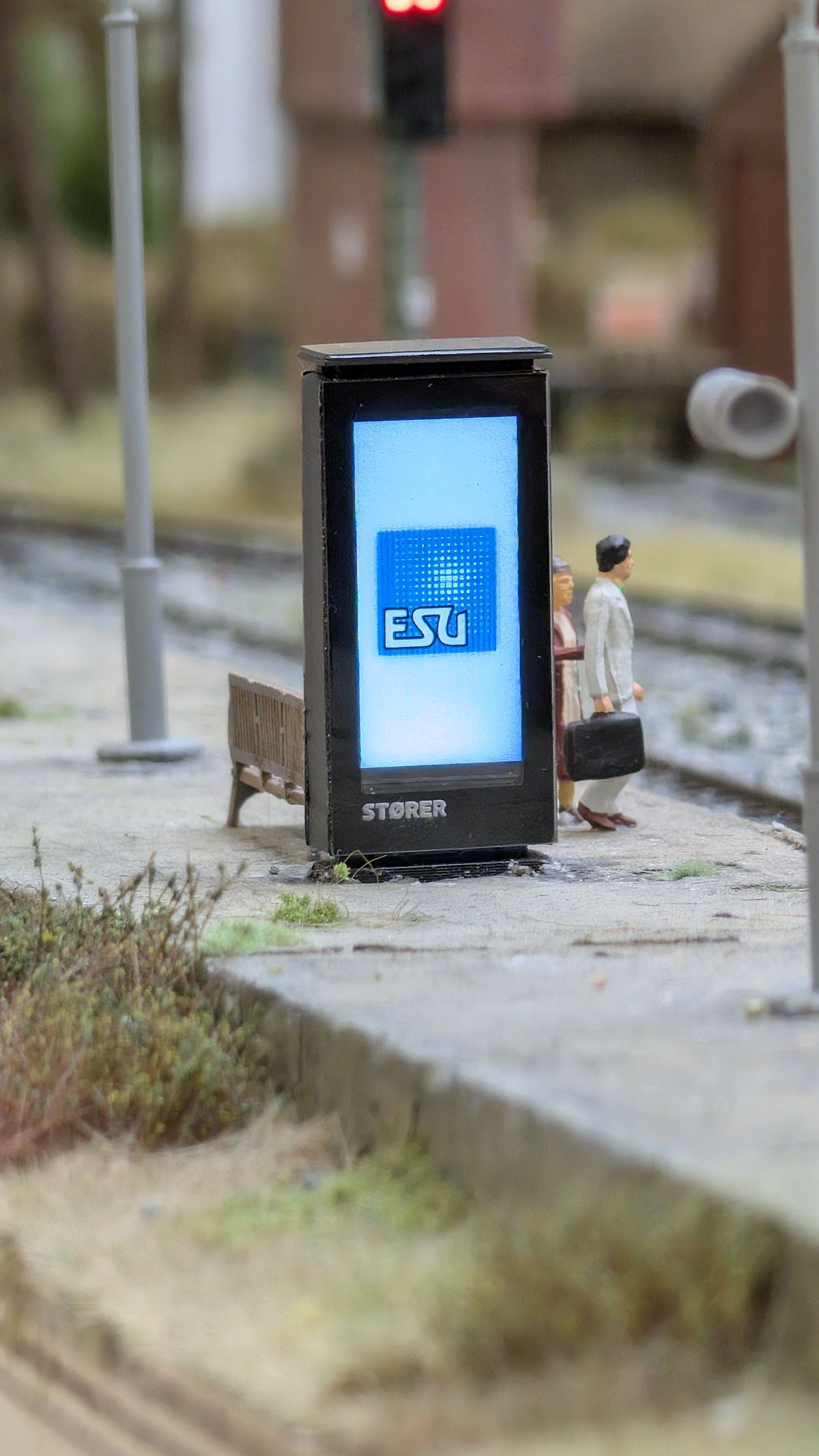 Beleuchtete Werbes&auml;ule mit ESU-Motiv an der Bahnsteigkante