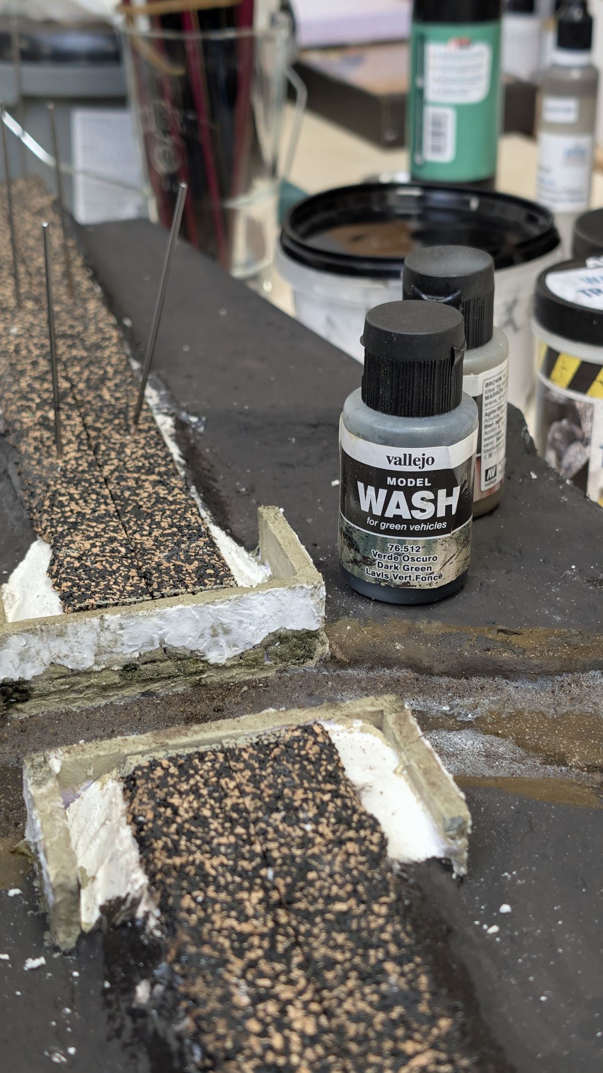 Fl&auml;schchen mit dunklem Wash am geschotterten Gleis